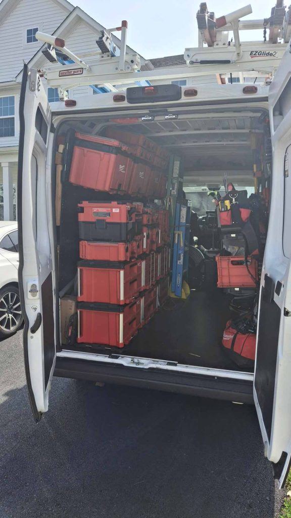 Estevez Electric LLC van, photographed from the back with the doors open to show off equipment inside